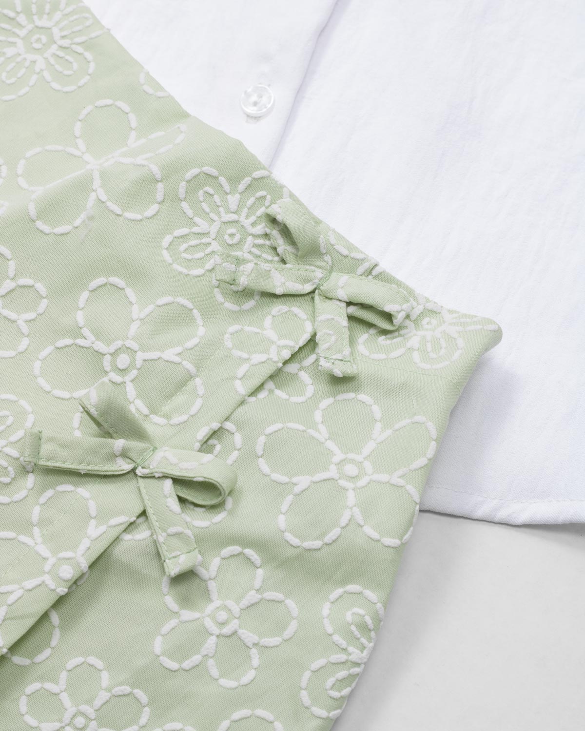 White sleeveless top with matching green floral skort