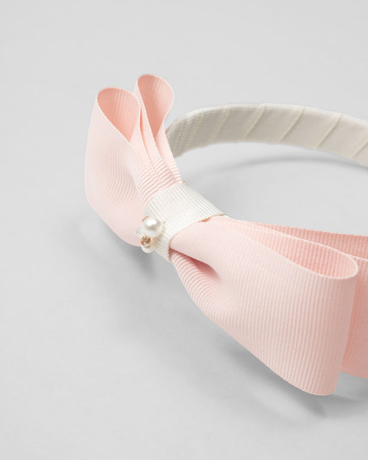 Headband with pink bow for girls.