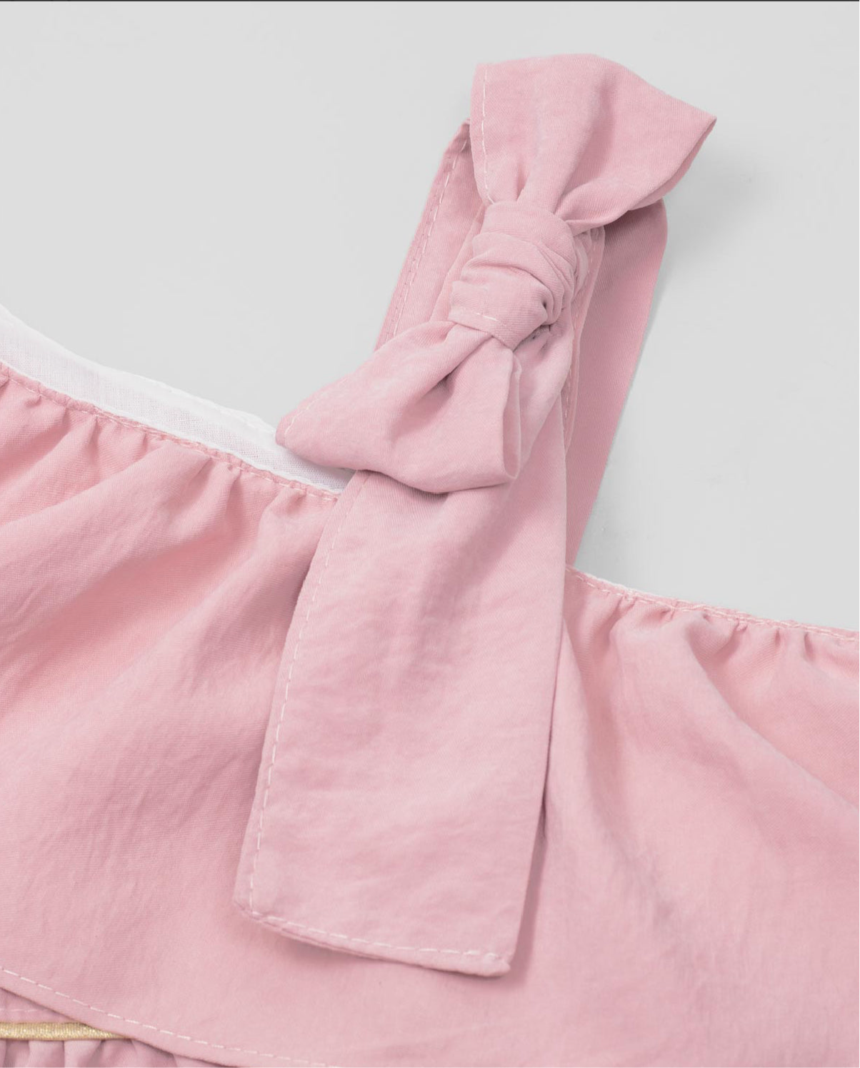 Pink dress with a wrap bolero, bow detail strap, and side button fastening for girls