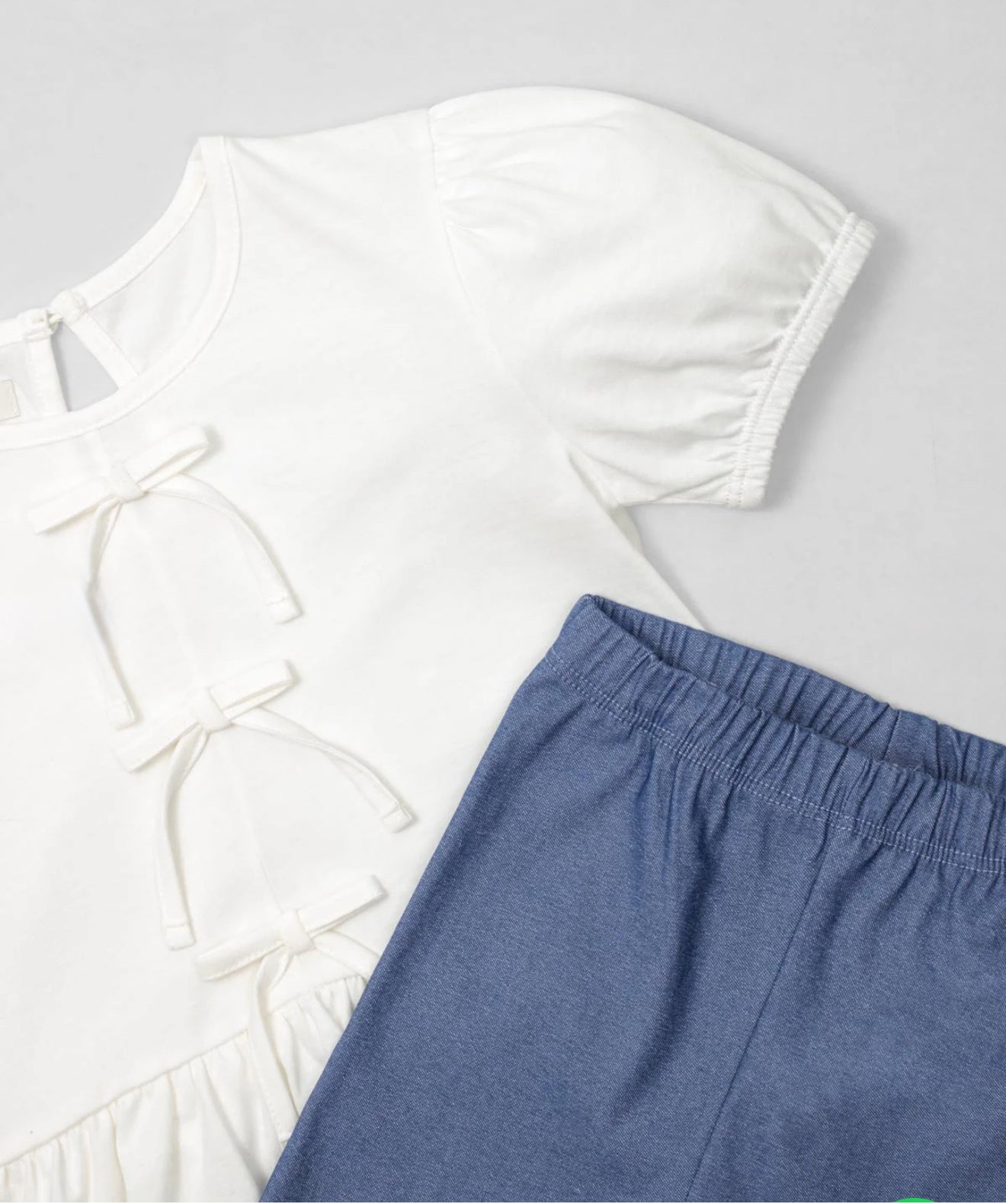 White blouse set with bow detail, finished with a bolero and blue leggings for girls
