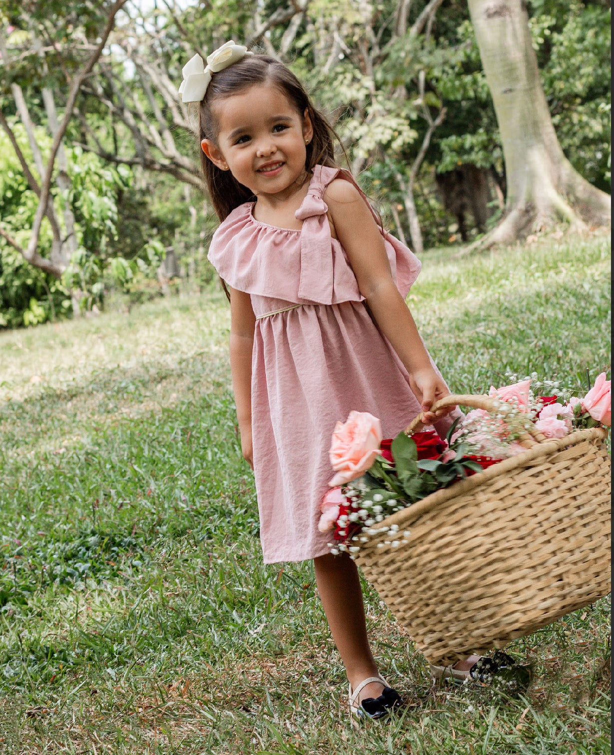 Pink dress with a wrap bolero, bow detail strap, and side button fastening for girls